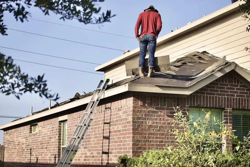 Professional roofer working on a residential roof in Financial District